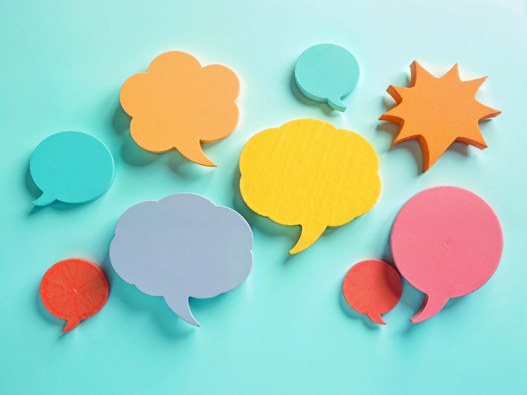 Bulles vibrantes découpées en papier sur fond turquoise, parfaites pour les thèmes de communication.